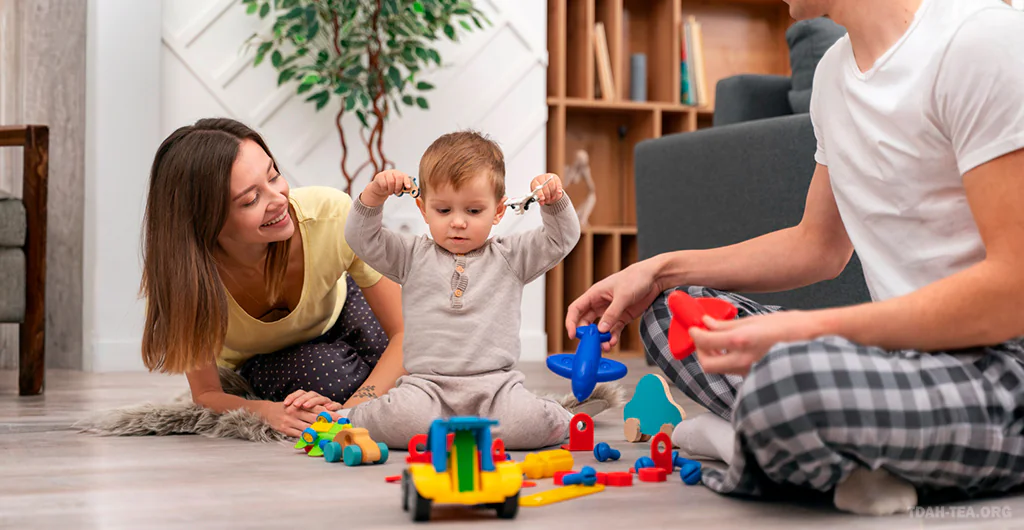 Familia vigilando el desarrollo de un niño de 2 años en una sala de estar - señales de alerta de TEA en niños de 2 a 3 años